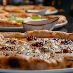 Delicious artisanal pizza with deep flavors and vibrant toppings on a rustic plate.